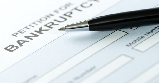 A pen on a blank form that reads "petition for bankruptcy"