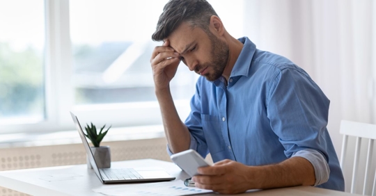 Worried man looking at cellphone