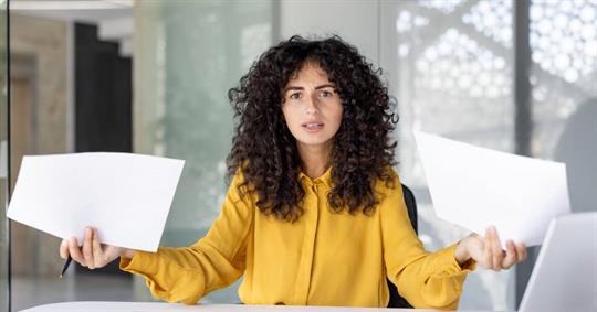 Confused and disappointed woman with documents in hands