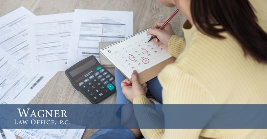 planning finances by checking calendar timeline and computing using a calculator